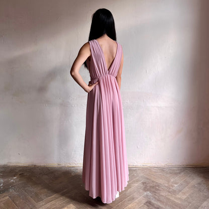 Modelka asijského původu pózující zezadu oblečená ve světle růžových společenských šatech