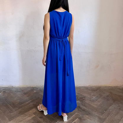 Modelka asijského původu pózující zezadu oblečená ve královsky modrých společenských šatech