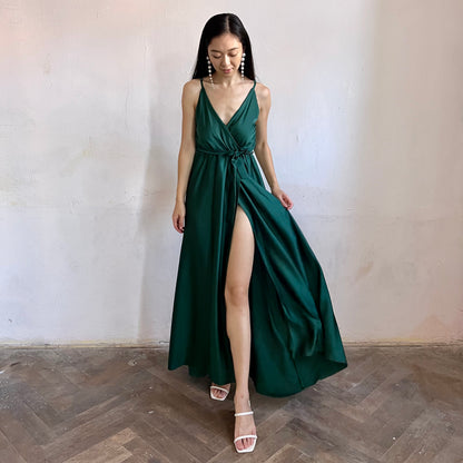 Modelka asijského původu pózující zepředu oblečená v tmavě zelených společenských šatech