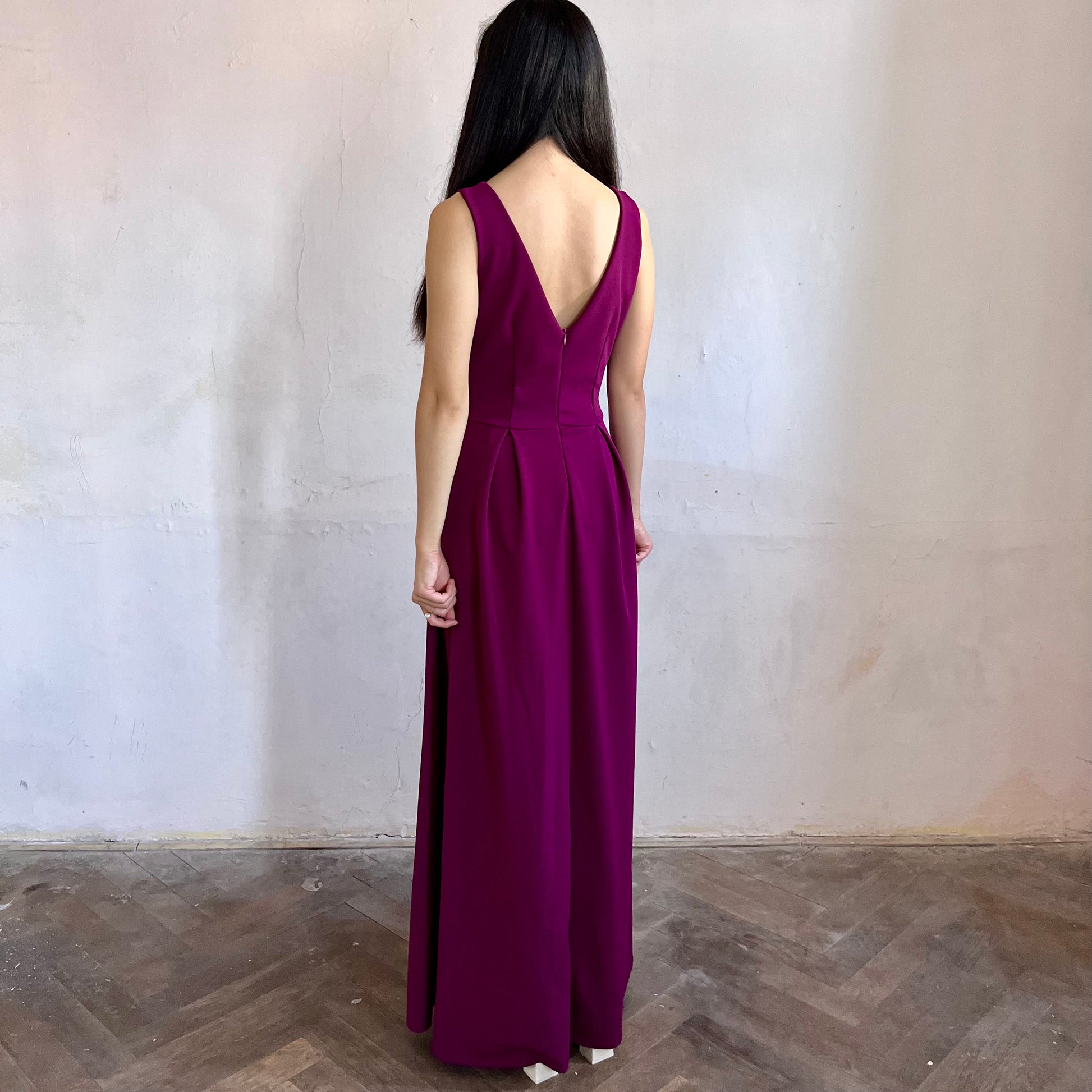 Modelka asijského původu pózující z boku oblečená ve fialových společenských šatech