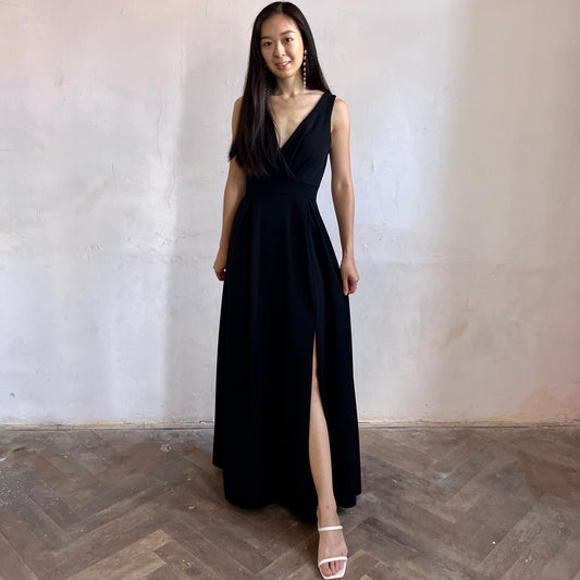 Modelka asijského původu pózující zepředu oblečená v černých společenských šatech