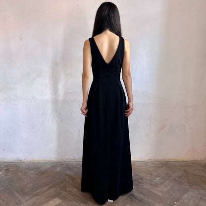 Modelka asijského původu pózující zezadu oblečená v černých společenských šatech
