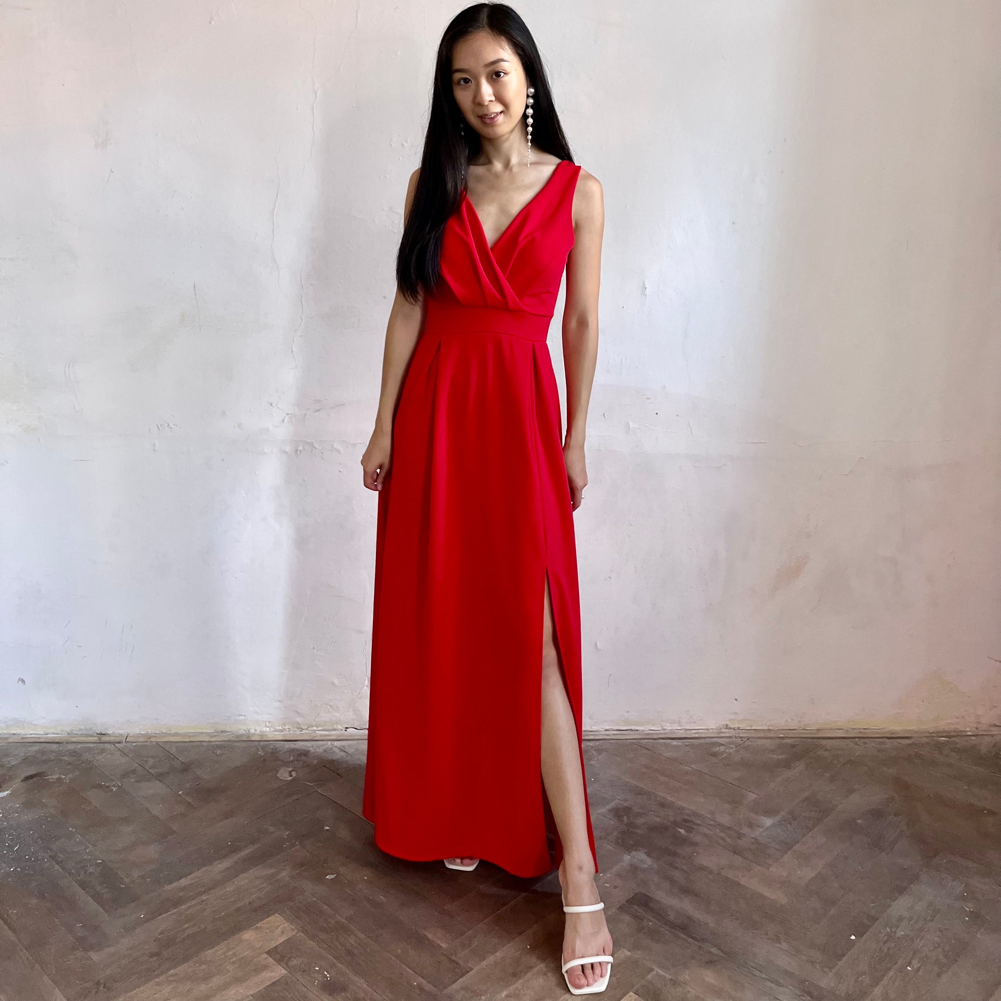Modelka asijského původu pózující zepředu oblečená v červených společenských šatech