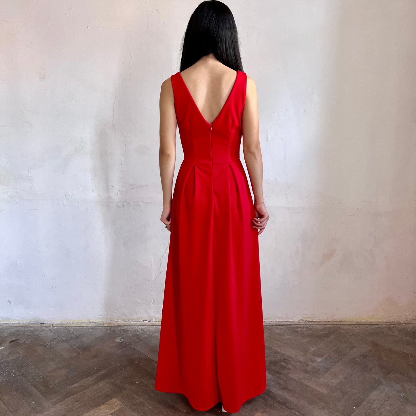 Modelka asijského původu pózující zezadu oblečená v červených společenských šatech