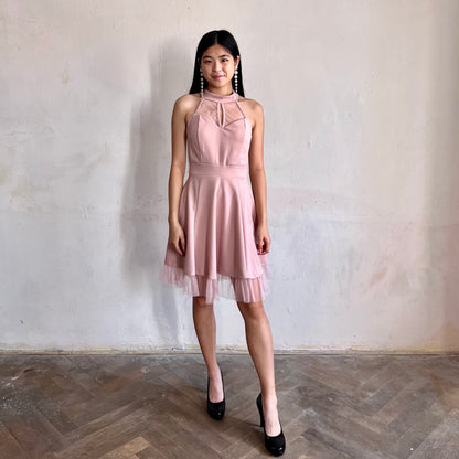 Modelka asijského původu pózující zepředu oblečená v růžových krátkých společenských šatech