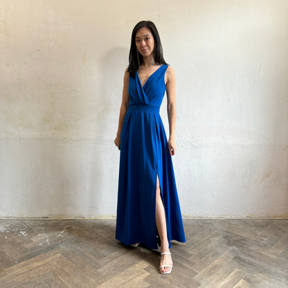 Modelka asijského původu pózující zepředu oblečená ve královsky modrých společenských šatech s rozparkem