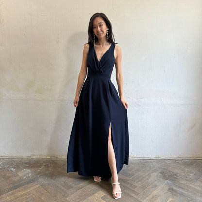 Modelka asijského původu pózující zepředu oblečená v tmavě modrých společenských šatech s rozparkem