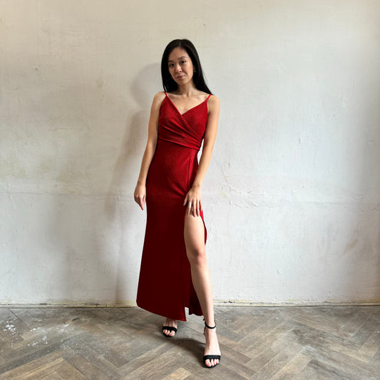 Modelka asijského původu pózující zepředu se třpytivými společenskými šaty v červené barvě
