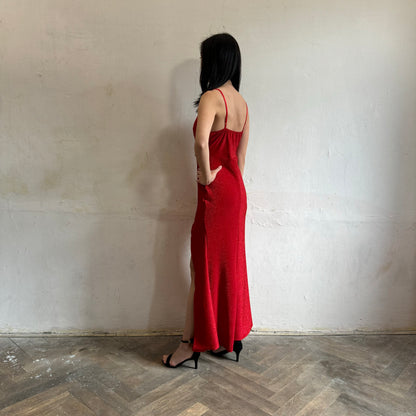 Modelka asijského původu pózující z boku se třpytivými společenskými šaty v červené barvě