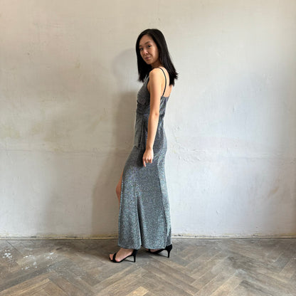Modelka asijského původu pózující z boku se třpytivými společenskými šaty ve stříbrné barvě