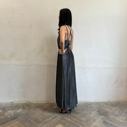 Modelka asijského původu pózující z boku se třpytivými společenskými šaty ve stříbrné barvě
