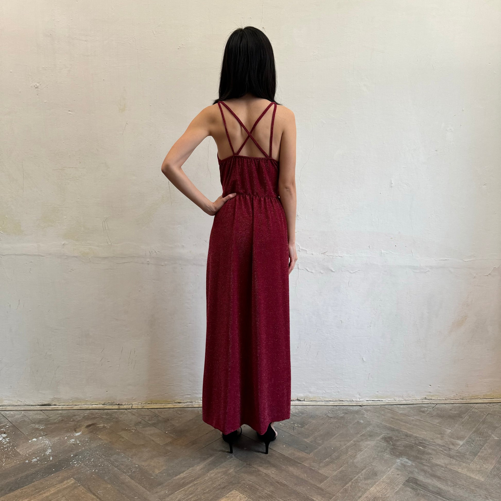 Modelka asijského původu pózující zezadu se třpytivými společenskými šaty ve vínové barvě